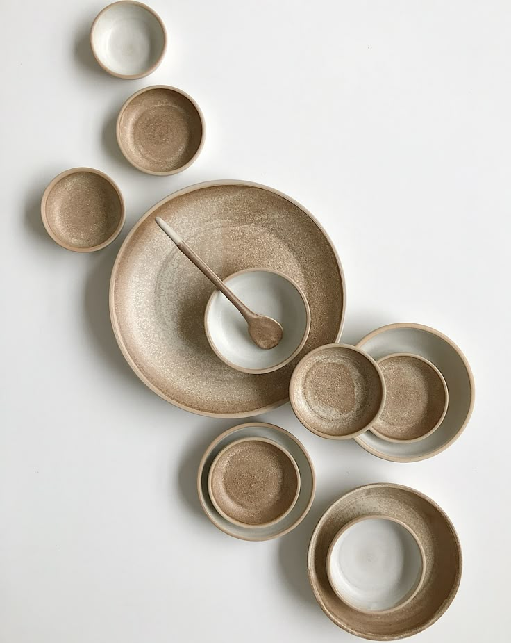 an assortment of bowls and plates on a white surface