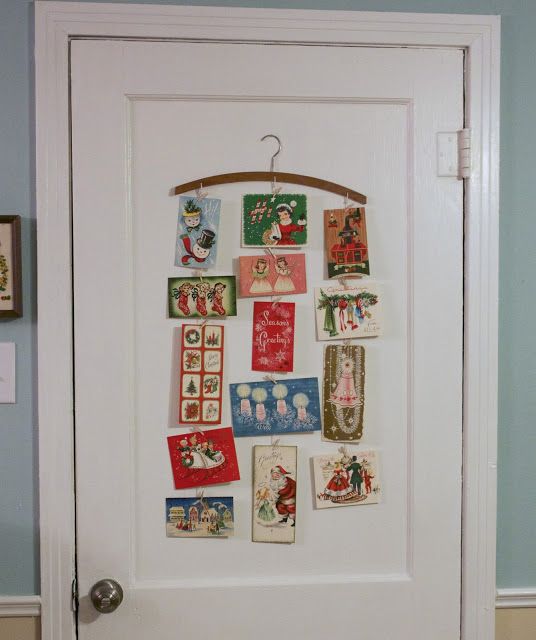 a door decorated with christmas cards and magnets on it's side, in front of a blue wall