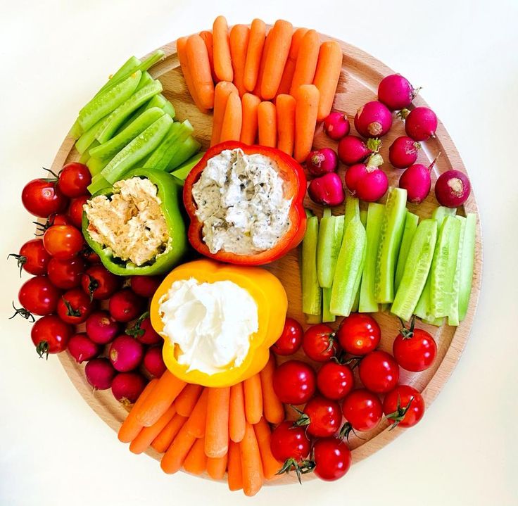 a platter with carrots, celery, tomatoes and other vegetables