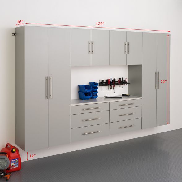 a garage with cabinets and tools in the center, including toolboxes on the wall