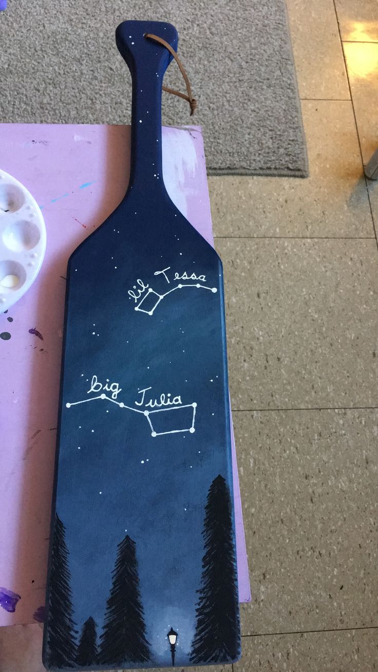 a long board with writing on it sitting on the ground next to some paint cans