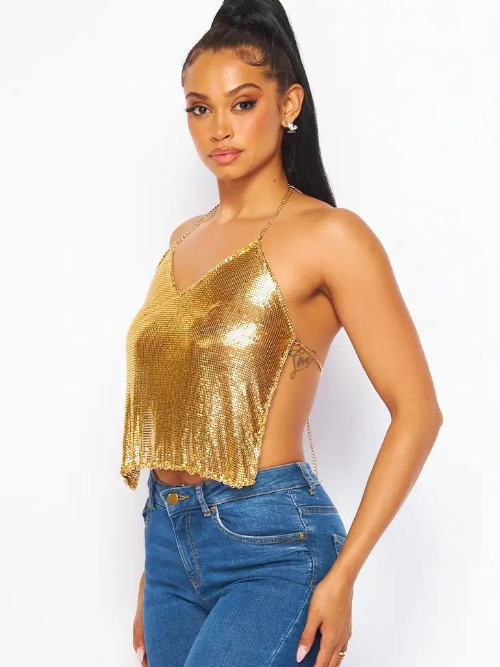 Be a show-stopper in our Metallic Chain Halter Crop Top! This daring gold top brings luxury and edge with its metallic chain detail and edgy halter design. Shine on the dance floor, turn heads, and show 'em your moves. (We know you got 'em! 🤩) Featuring Chain Mail with Metallic Chain Trim, Halter V Neck Line, Adjustable Back Clasp Closures, Cropped Length, Unlined/Sheer. 100% Aluminum Glamorous Gold Sleeveless Halter Top, On The Dance Floor, Gold Top, Halter Crop Top, Chain Mail, Top Crop, Shine On, Neck Line, Dance Floor