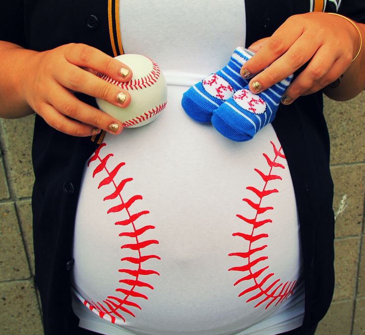 a pregnant woman holding two baseballs in her belly