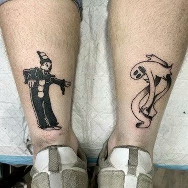 two people with tattoos on their legs, one has a clown and the other has a cat