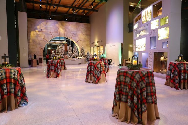 tables covered with red and black plaid cloths are set up in a large room