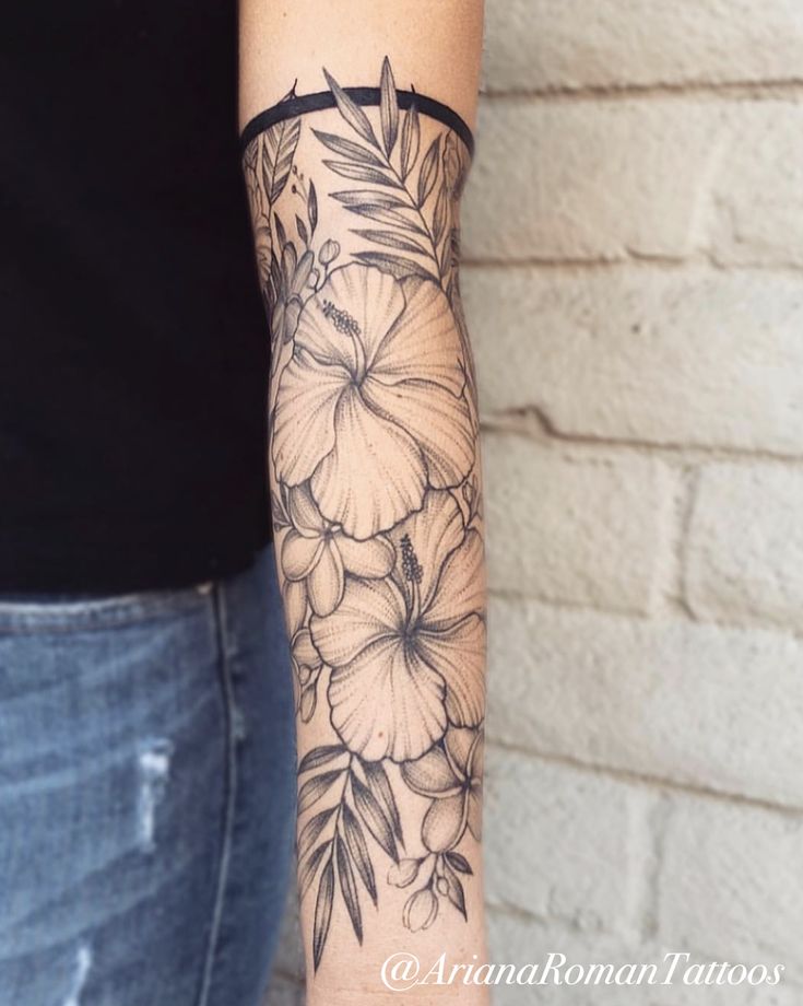 a woman's arm with flowers on it and a black band around the wrist