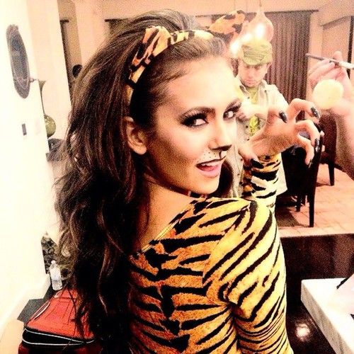 a woman dressed in tiger print poses for the camera