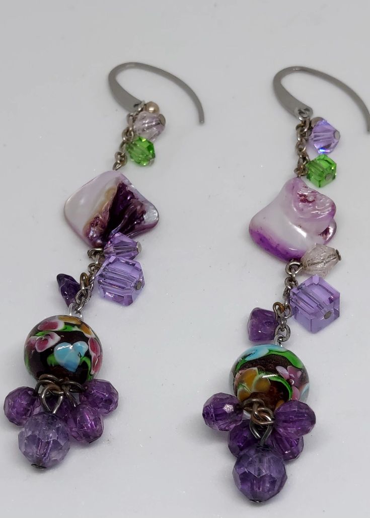 Pretty purple combination of glass, acrylic, and mother of pearl earrings. Approximately 3" inches in length. Ear hooks are surgical steel. Purple Czech Glass Earrings For Gift, Purple Drop Earrings With Dangling Beads, Purple Dangle Earrings With Beads, Adjustable Purple Chandelier Drop Earrings, Purple Czech Glass Dangle Earrings, Bohemian Purple Earrings Made Of Czech Glass, Purple Dangle Earrings With Ear Wire, Purple Dangle Earrings With Czech Glass, Purple Czech Glass Jewelry With Dangling Beads