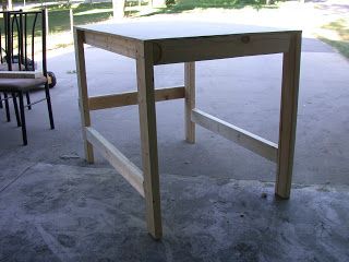 a wooden table sitting on top of a cement floor