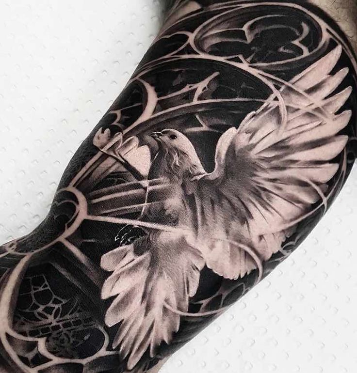 a man's arm with a bird and flowers tattoo on it