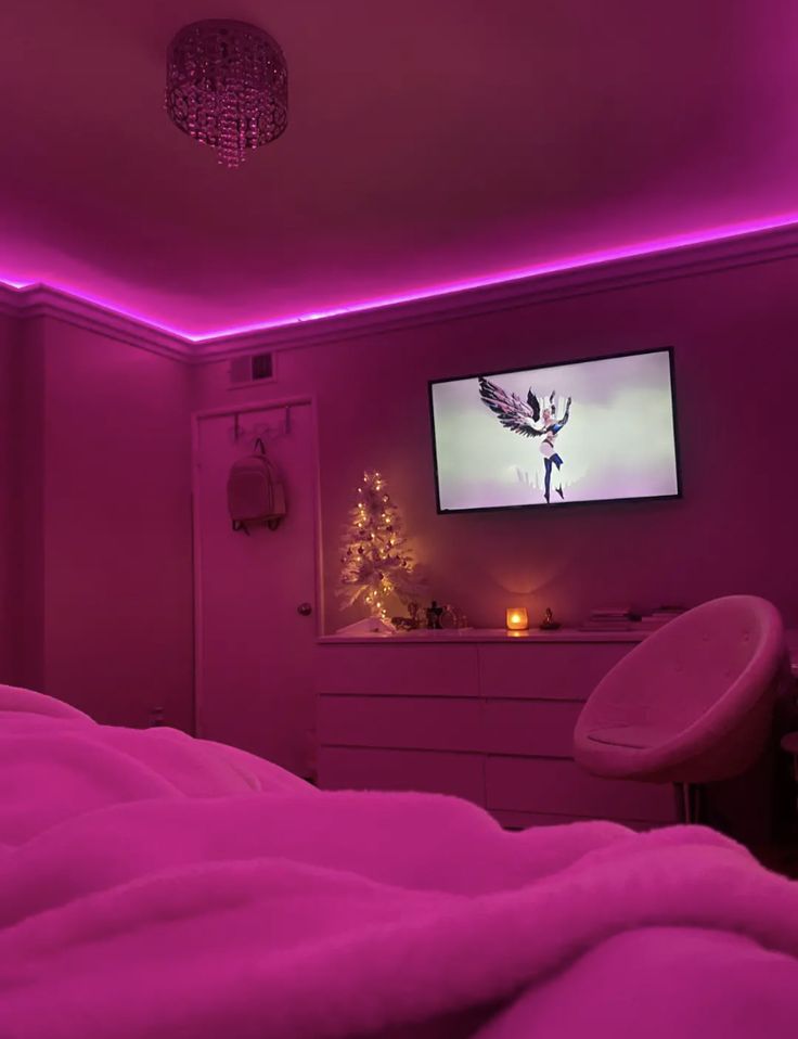 a bedroom with pink lighting and a flat screen tv