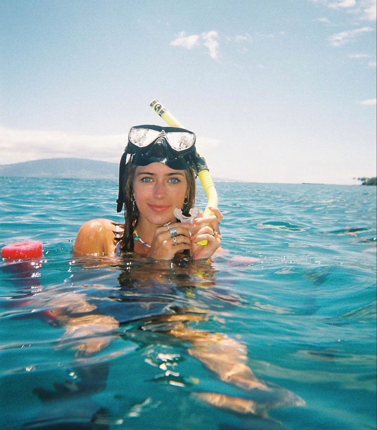 a woman is swimming in the ocean with her snorkels