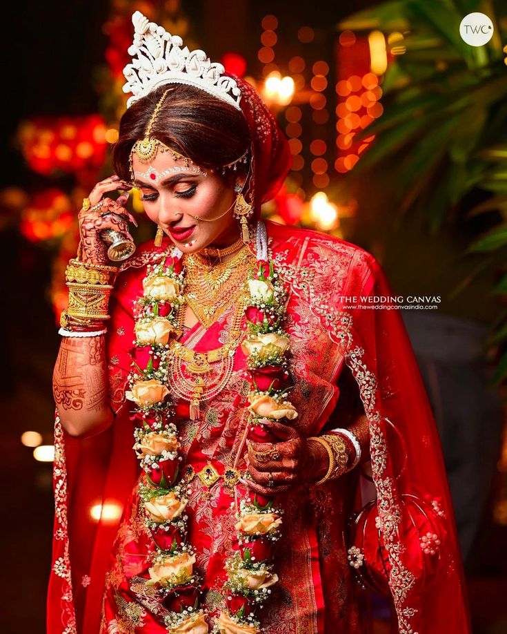 a woman dressed in red and gold is talking on her cell phone