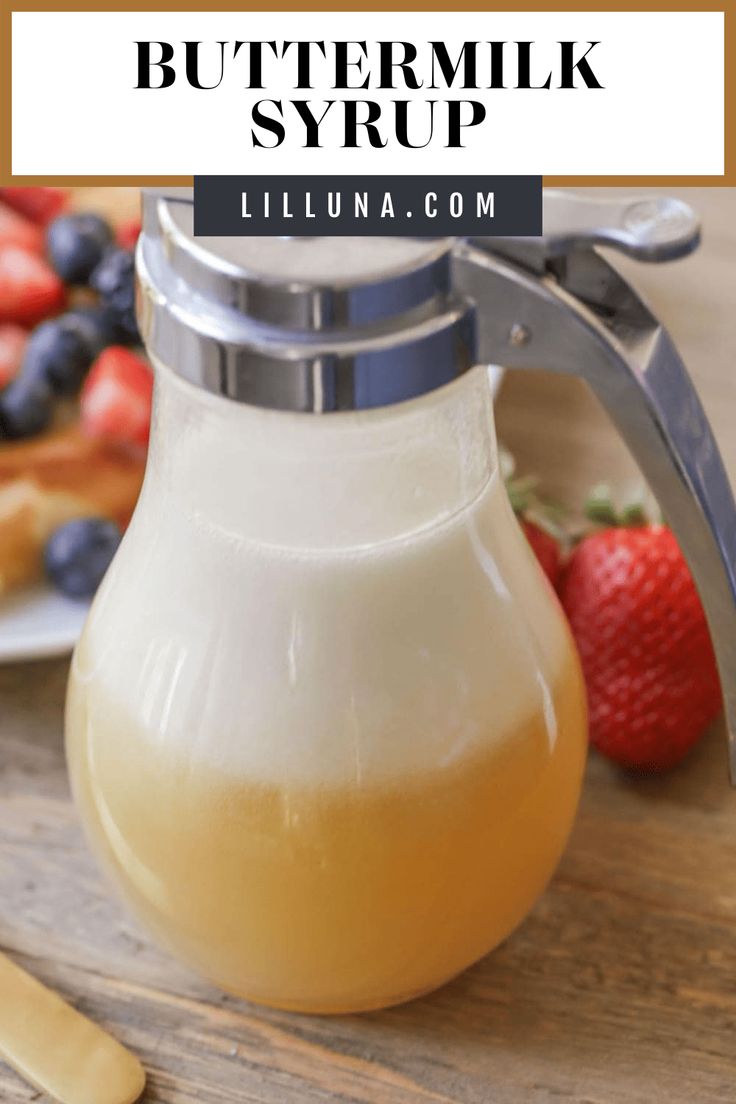 a pitcher of buttermilk syrup next to sliced strawberries