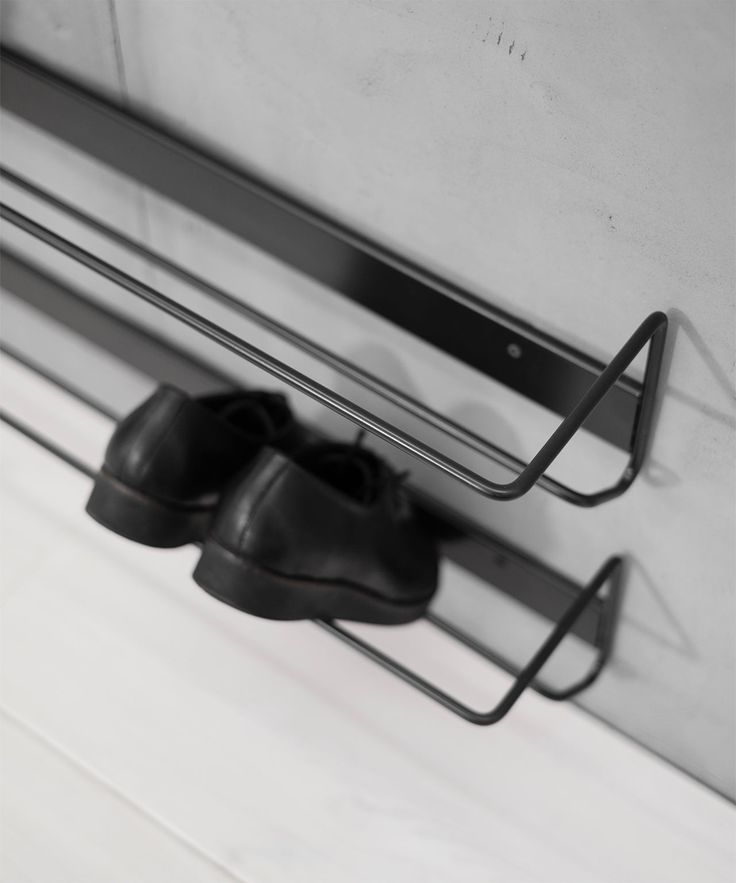 a pair of black shoes hanging on a metal rack