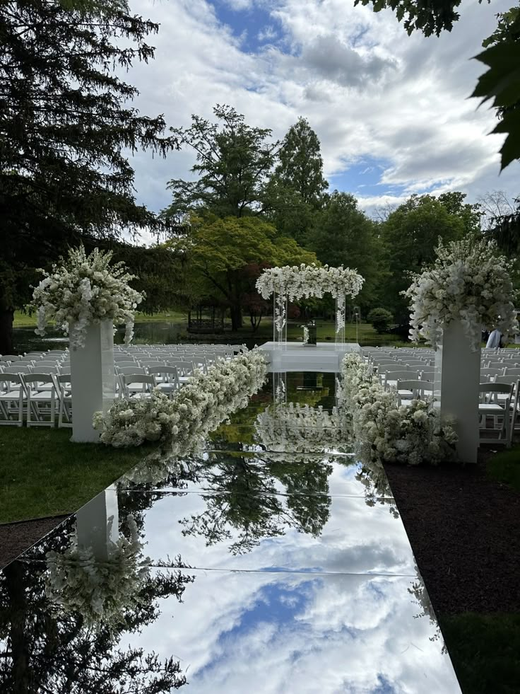 an outdoor ceremony setup with white flowers and greenery