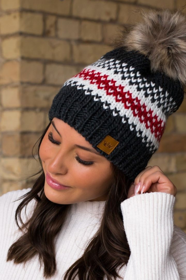 a woman wearing a black, white and red hat with pom - pom