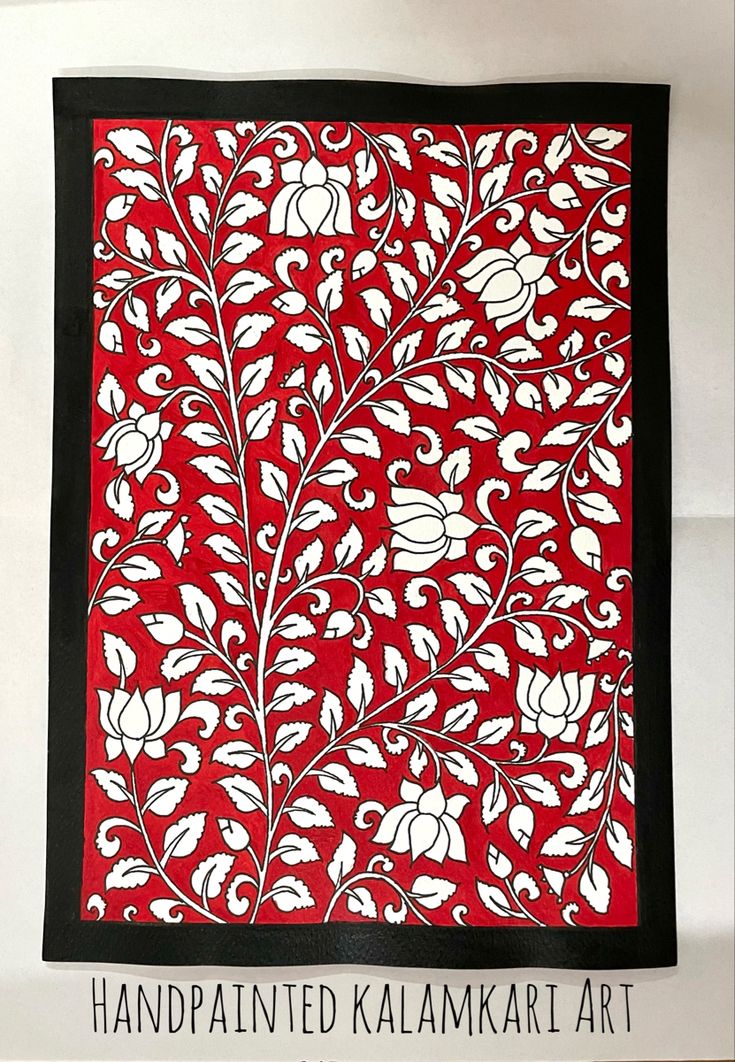 an intricately designed red and black cloth with white flowers on the border is displayed