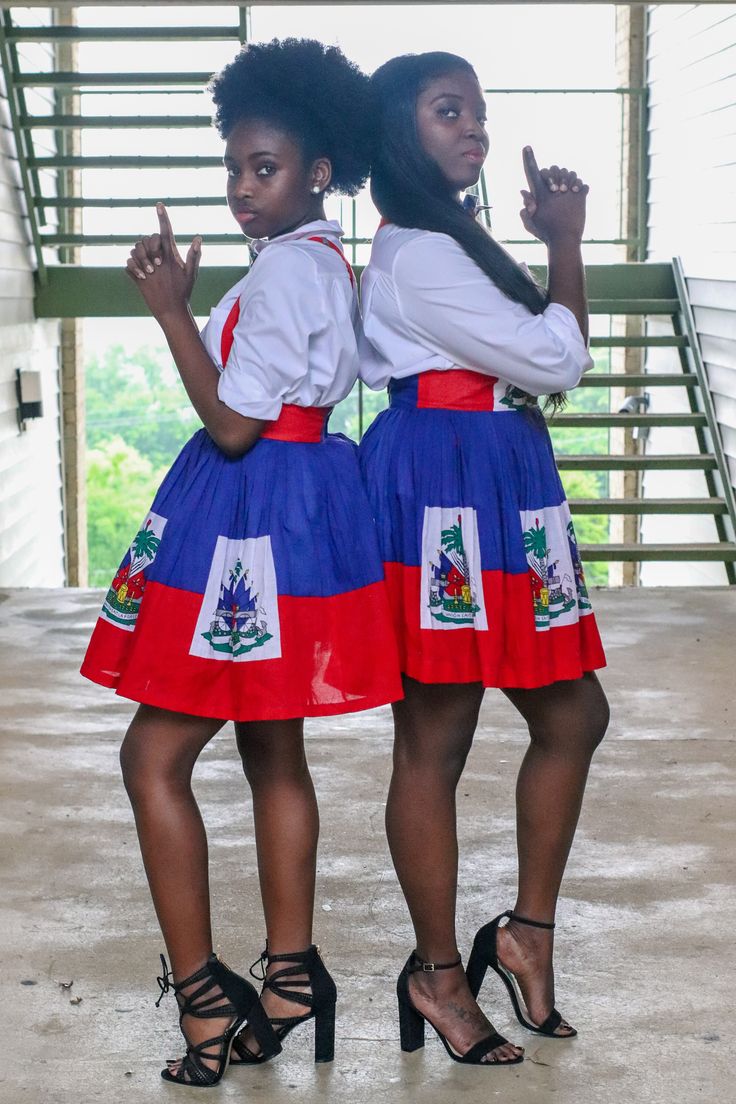 two women in dresses standing next to each other and making the peace sign with their hands