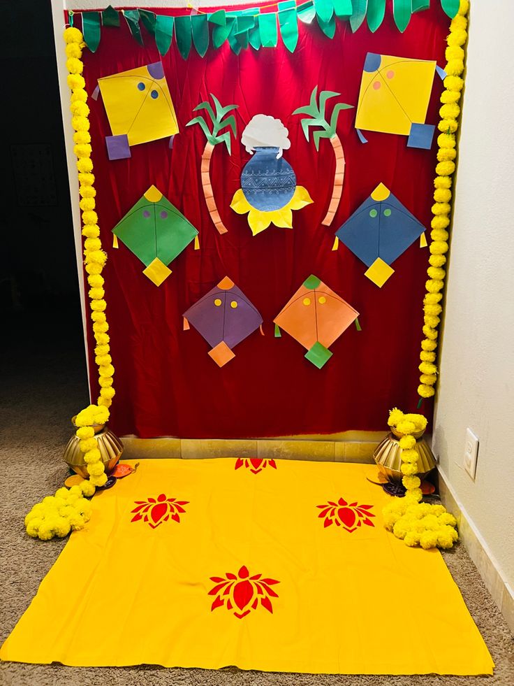 a room decorated in yellow and red with decorations on the wall, along with pom poms