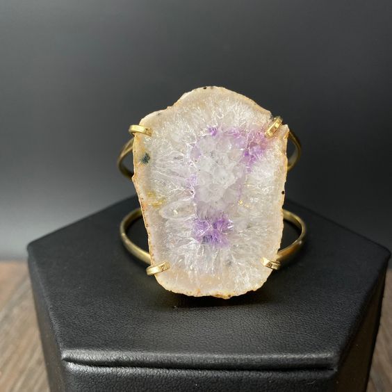 Naturally occurring, raw crystal edged geode slice. Prong set in gold tone, very pliable, fully adjustable. Gorgeous statement piece! style 1 length approx. 1 3/4" width approx. 1 1/3" style 2 length approx. 1 3/4" width approx. 1" Adjustable Gold Jewelry With Raw Stone, Geode Slice, Gold Bracelet Cuff, Raw Crystal, Prong Setting, Cuff Bracelet, Statement Pieces, Gold Bracelet, Gold Tones