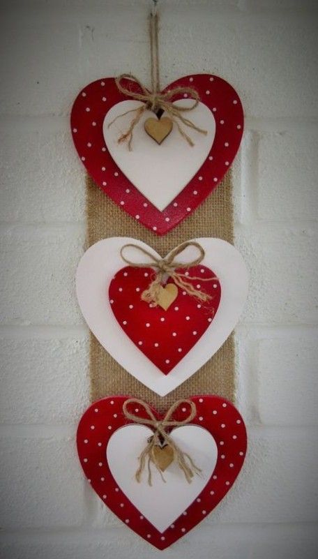 three red and white hearts hanging on a wall