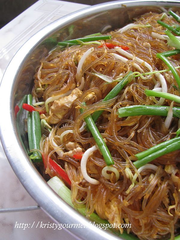 a silver bowl filled with noodles and vegetables