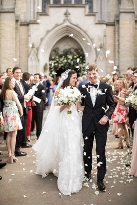 a bride and groom walking through confetti in front of an old church door