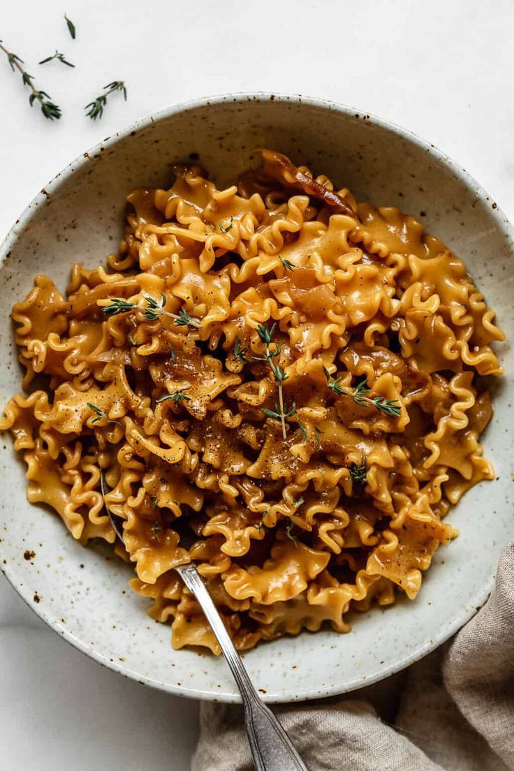 a white bowl filled with pasta and meat