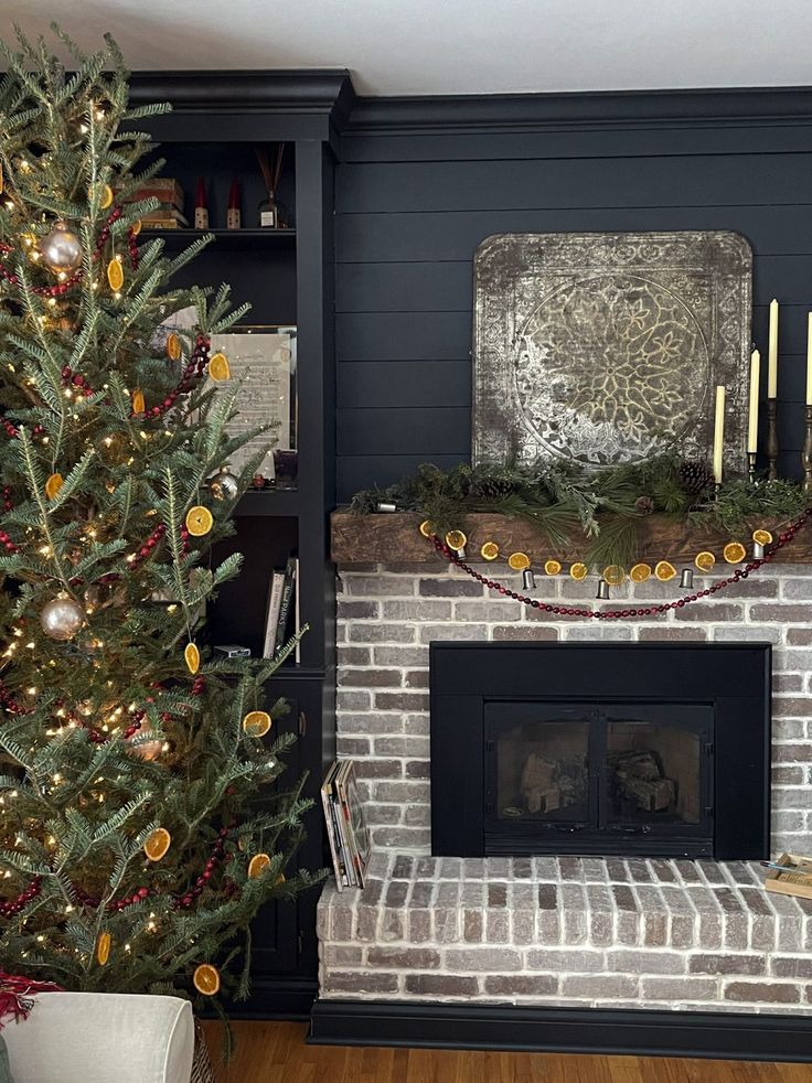 a decorated christmas tree in front of a fireplace