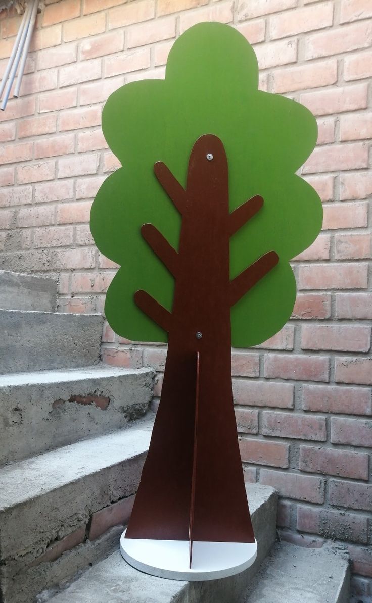 a tree shaped sculpture sitting on top of cement steps next to a brick wall and stairs