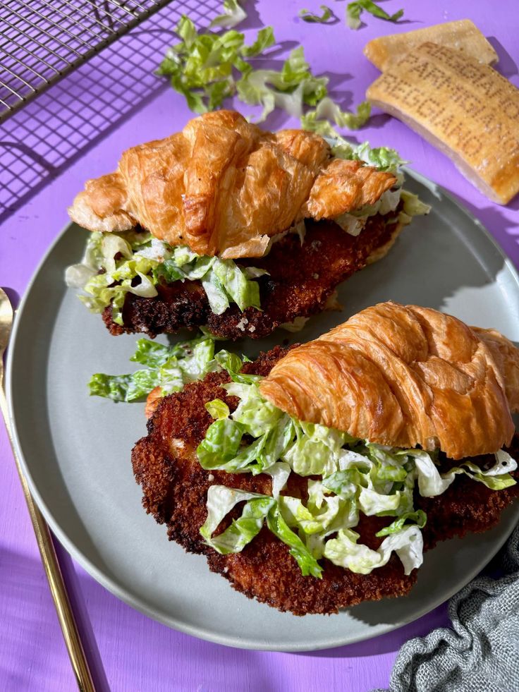 two croissant sandwiches with lettuce and meat