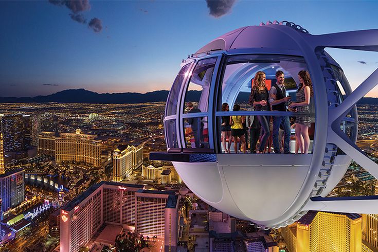 people standing on the top of a ferris wheel at night in las vegas, nevada