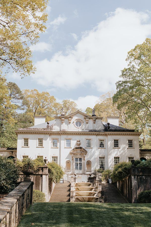 a large white house sitting on top of a lush green field