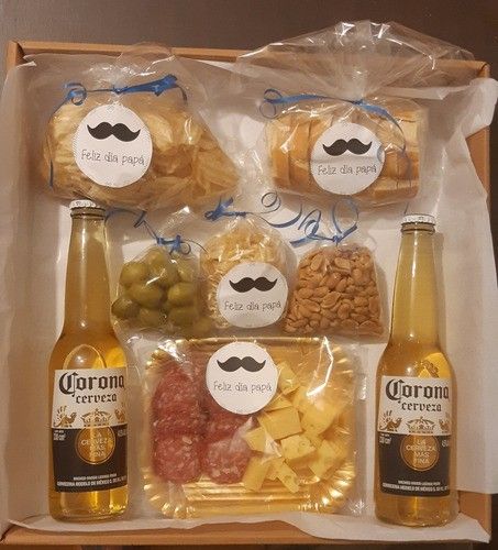 an open box filled with different types of food and drinks in plastic wrappers on top of a wooden table