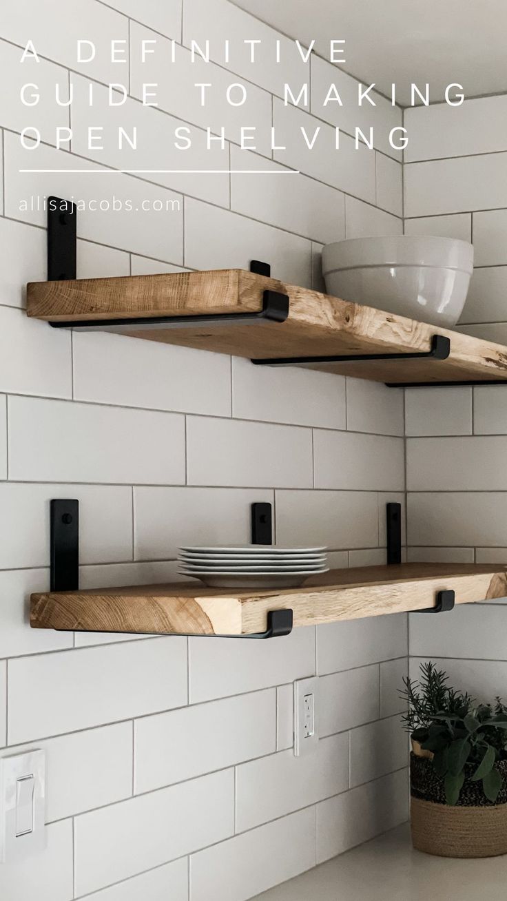 two open shelving shelves in a kitchen with white tile and black brackets on the wall