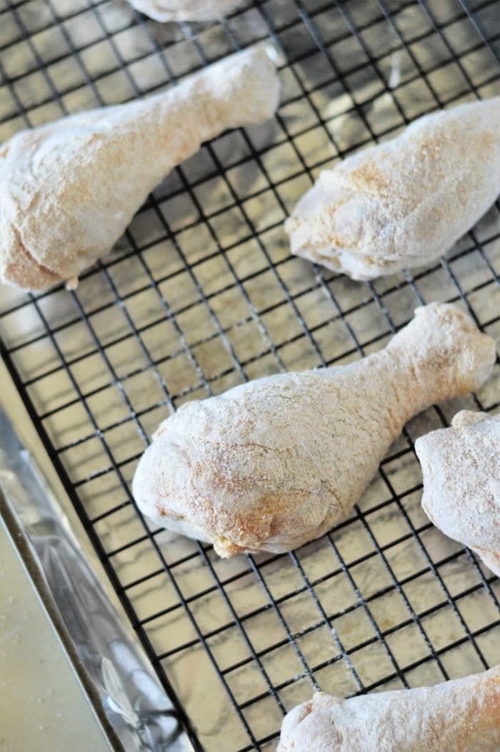 raw chicken wings on a cooling rack ready to go in the oven for roasting