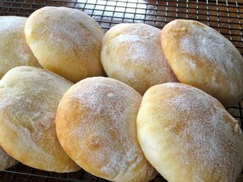 six sugar - coated doughnuts cooling on a wire rack, ready to be baked