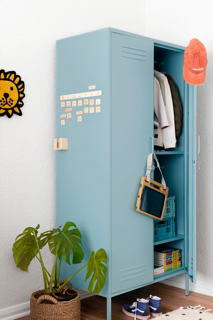 a blue locker next to a potted plant in a room