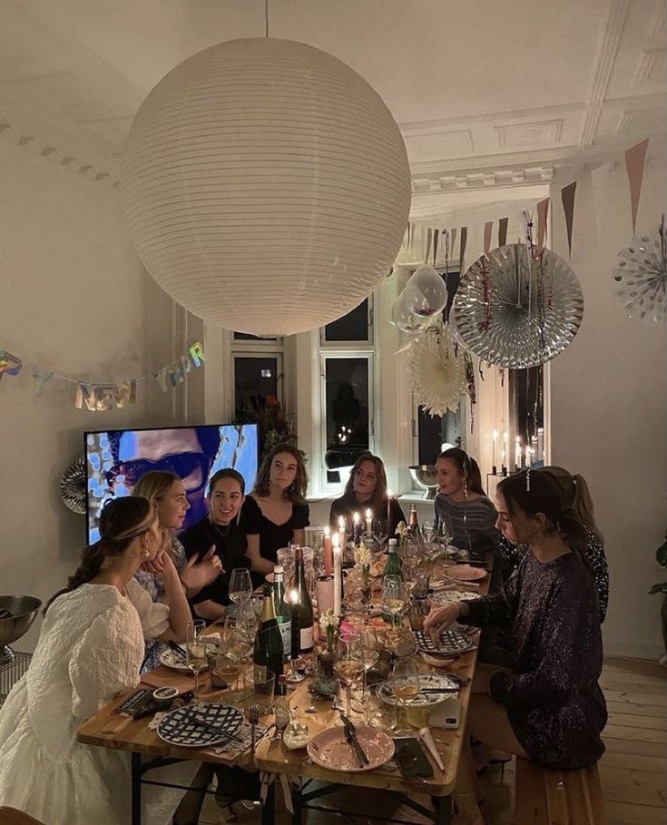 a group of people sitting around a table with food