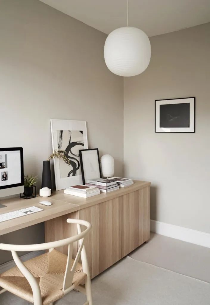 a desk with two computers and pictures on it