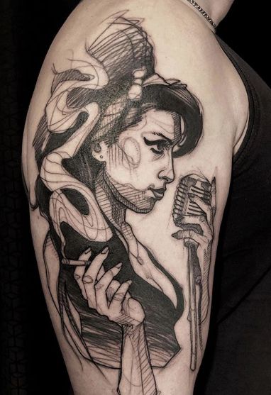 a woman with a microphone tattoo on her arm