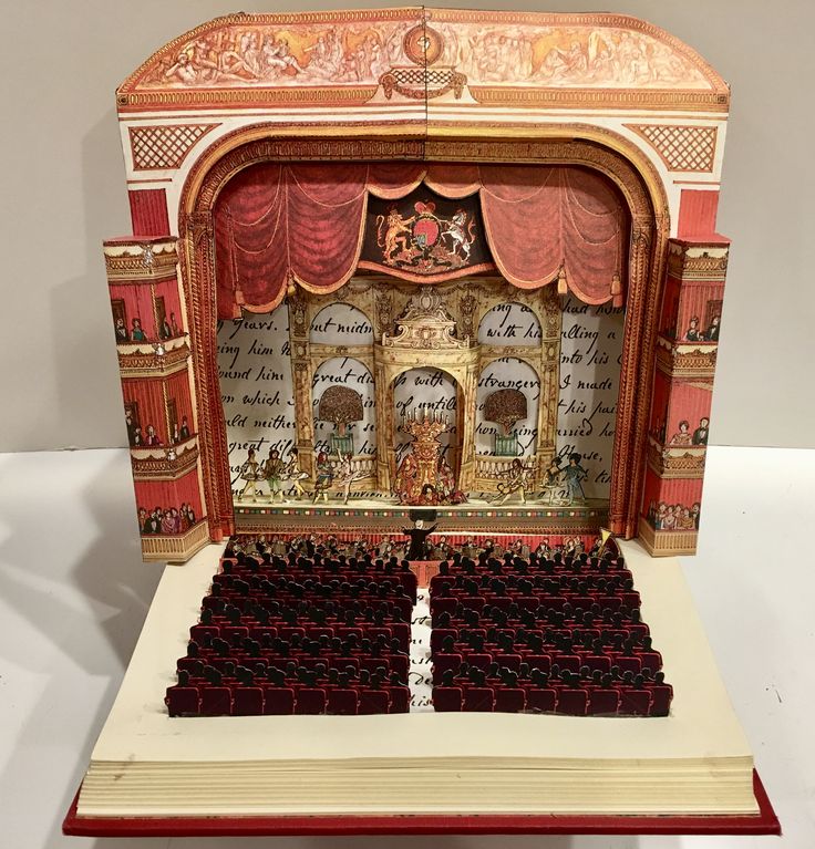 an open book that is sitting on top of a table in front of a stage