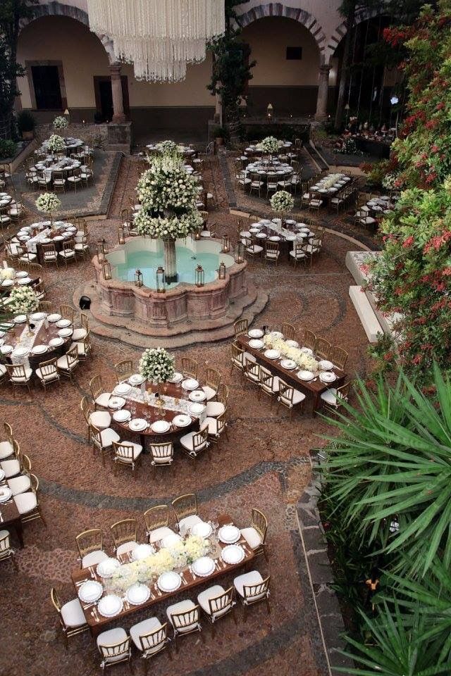 tables and chairs are set up in the middle of an outdoor courtyard with water fountain