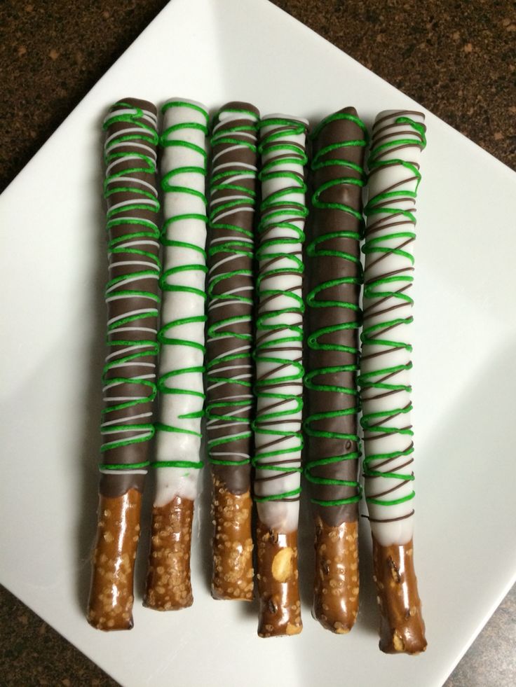 four pieces of food wrapped in green string on a white plate