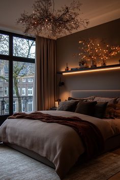 a bedroom with a large window and a chandelier hanging from it's ceiling