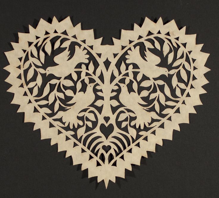 a heart shaped cutout with birds and flowers on it's sides, in the shape of an ornament