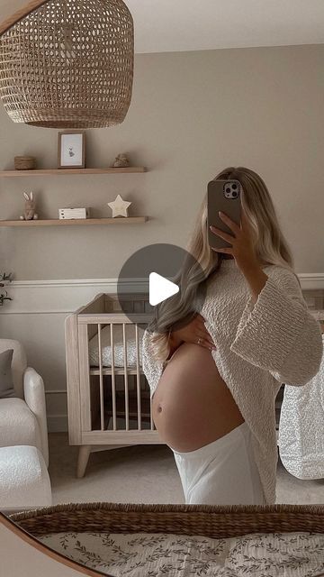 a woman taking a photo of herself in her bedroom with the baby's crib