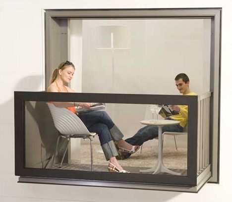 two people sitting on chairs in front of a flat screen tv that is mounted to the wall