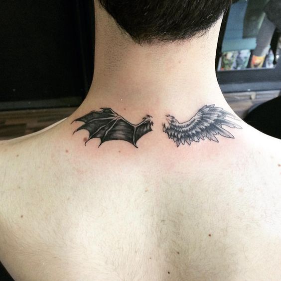 the back of a man's neck with a bat tattoo on his left side